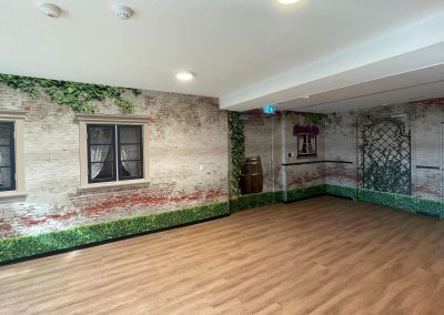 Voor deze afdeling wilden ze een binnentuin creëren. Met fotobehang en folie is een ruimte gecreëerd waar bewoners zich even buiten wanen.
